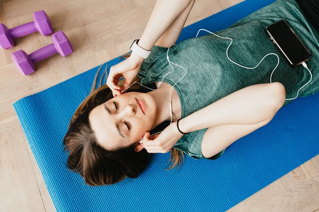 A woman listening to audio through her earphones.